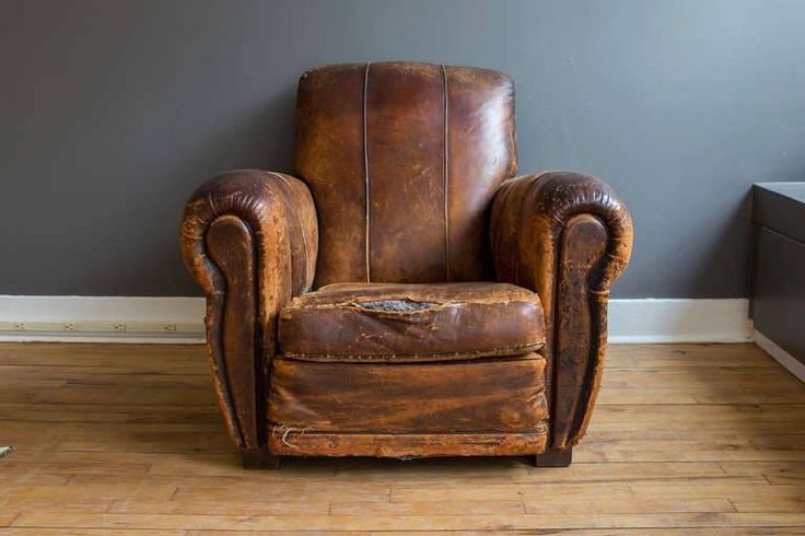 Old armchair with dated, worn floral fabric upholstery